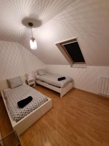 a room with two beds and a window and a ceiling at Demeure de charme paisible in Villepinte