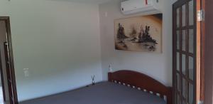 a bedroom with a bed and a picture on the wall at Aconchego em Floripa in Florianópolis