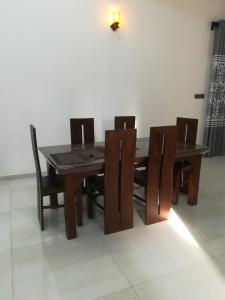a dining room table with chairs and a wooden table and chairsktop at Wood Land Villa in Ambalantota