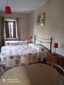1 Schlafzimmer mit 2 Betten, einem Tisch und einem Fenster in der Unterkunft The Wishing Well in Gallinaro