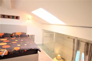 a small bedroom with a bed and a skylight at Duplex lumineux et spacieux in Nice