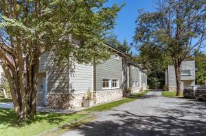 una casa con un coche aparcado junto a una entrada en BOG Las Frutillas 1, en Villa La Angostura