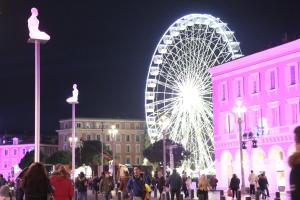 a large ferris wheel in a city at night at Duplex lumineux et spacieux in Nice