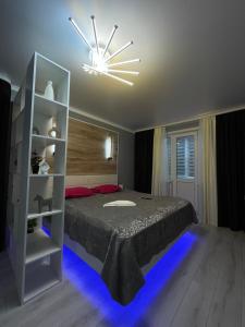 Un dormitorio con una cama con luces azules. en Бизнесс Апартаменты Центр Уральск en Oral