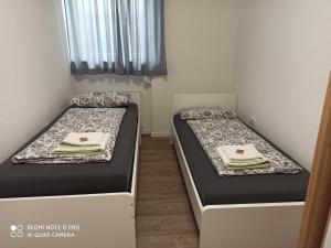 two beds in a small room with sidx sidx sidx at Adessa Apartment in Bad Mergentheim