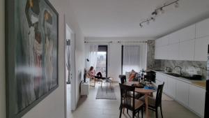 a kitchen and living room with a table and chairs at Serenade Apartment in Korçë