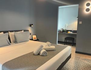 a bedroom with a bed with towels on it at Victoria by Petit Chic in Mellieħa