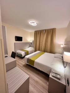 a hotel room with two beds and a tv at Hotel Aurora in Mestre