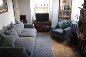 a living room with two couches and a television at Fisherman's Cottage in Pennan in Pennan