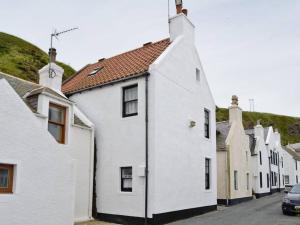 a row of white houses on a street at Fisherman's Cottage in Pennan in Pennan