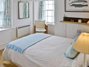 a bedroom with a bed with a lamp and a chair at Fisherman's Cottage in Pennan in Pennan