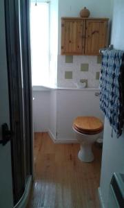 a bathroom with a wooden toilet and a window at Fisherman's Cottage in Pennan in Pennan