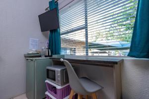 un bureau avec une chaise en face d'une fenêtre dans l'établissement Rozelee Rest, à Nelspruit