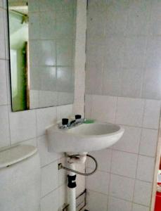 - białą umywalkę w łazience z lustrem w obiekcie La alpina de YOLI w mieście Ushuaia