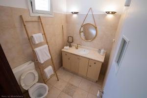 a bathroom with a toilet and a sink and a mirror at הסמטה של יפו in Tel Aviv