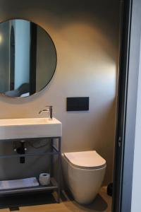 a bathroom with a sink and a toilet and a mirror at Victoria by Petit Chic in Mellieħa +31 photos