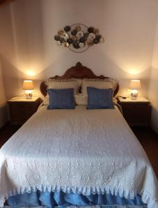 1 dormitorio con 1 cama grande con almohadas azules en O Cobo vacacional en A Coruña