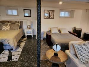 a hotel room with two beds and a couch at Cozy Studio; Lower Level Unit in Laurelton