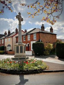 a statue of a cross in front of a house at Historic & Stylish Cottage in Charlton Kings