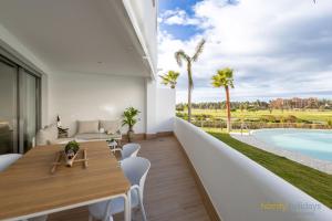 a dining room with a table and a view of a pool at Homity Exclusive Playa Granada Beach & Golf - Mar de Astrid in Motril
