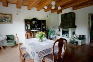 a dining room with a table and a fireplace at Uroczysko Leźno in Małe Leżno