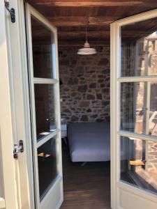 otwarte drzwi prowadzące do pokoju z kanapą w obiekcie Lemon's Cottage House, Volissos, Chios w mieście Volissos