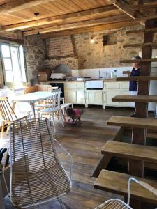a woman in a kitchen with a table and chairs at Lemon's Cottage House, Volissos, Chios in Volissos +53 photos