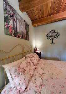 Schlafzimmer mit einem Bett mit rosa Tagesdecke in der Unterkunft Agriturismo La Valle Dimenticata in Urbania