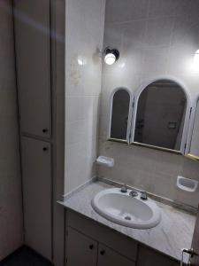 baño con lavabo y 2 espejos en La Porota en Ramallo