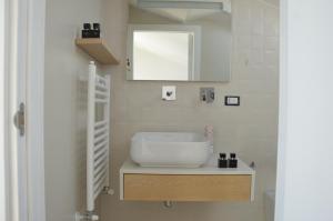 Deliziosa Villetta في تيرمولي: حمام مع حوض أبيض ومرآة