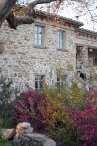 una casa de piedra con flores delante en Podere Paradiso, en Magione