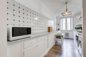 ローマにあるリビング ローマ レプブリカ アパートメントの白いキャビネット付きのキッチン、カウンターのテレビ付