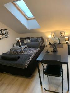 a bedroom with a bed and a table and a skylight at Apartment Luna in Maribor