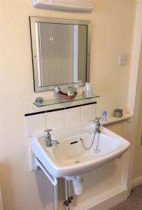 a white sink in a bathroom with a mirror at Grey Mullet Guest House in St Ives