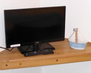 a computer monitor sitting on top of a wooden shelf at Grey Mullet Guest House in St Ives