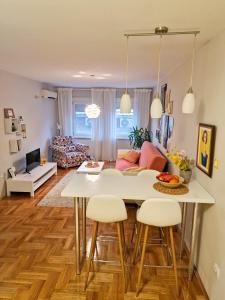 a kitchen and living room with a table and chairs at Quiet Center in Sremska Mitrovica