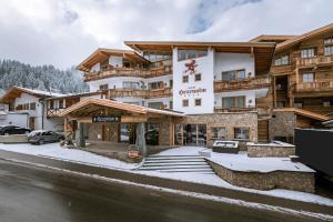 duży budynek z śniegiem na ziemi w obiekcie Hotel Restaurant Hexenalm w mieście Söll