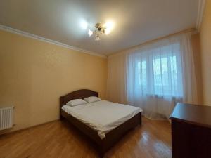 um pequeno quarto com uma cama e uma janela em Однокімнатна біля автостанції, вулиця Зацепи em Lutsk