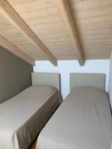 two beds in a room with wooden ceilings at Cascina Jesolana in Lido di Jesolo +30 photos