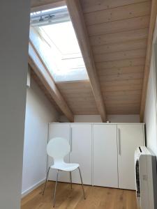 Habitación con silla blanca y tragaluz. en Cascina Jesolana, en Lido di Jesolo