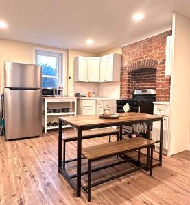 a kitchen with a table and a stainless steel refrigerator at Classical Isbills Row House close to NYC in Bayonne