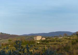 a house on a hill in the middle of a field at Podere Paradiso in Magione