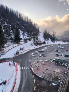 Una carretera con coches aparcados en la nieve en Studio Azur Mercantour en Valdeblore