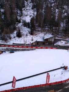 une route recouverte de neige à côté d'un bâtiment dans l'établissement Studio Azur Mercantour, à Valdeblore