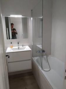 een man die een foto neemt van een badkamer met een wastafel en douche bij Studio Azur Mercantour in Valdeblore