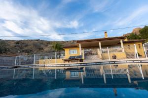 una casa amarilla con una piscina frente a ella en Casa Rural Familiar Piscina Sierra Balumba, en Cobatillas