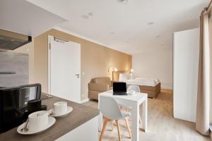 a living room with a bed and a desk with a laptop at Boardinghotel Premium Heidelberg in Heidelberg