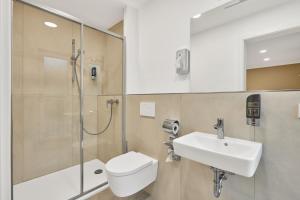 uma casa de banho com um chuveiro, um WC e um lavatório. em Boardinghotel Premium Heidelberg em Heidelberg