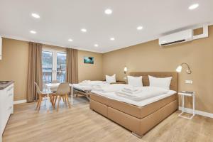 Habitación de hotel con 2 camas, mesa y sillas en Boardinghotel Premium Heidelberg en Heidelberg