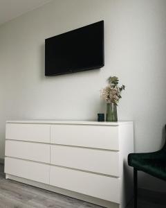 a white dresser with a television on a wall at MoonLight in Slavske